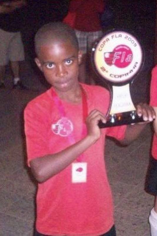 Vini Jr ainda criança, de camisa vermelha, segurando o troféu da Copa Fla 2009, sua primeira taça no Flamengo