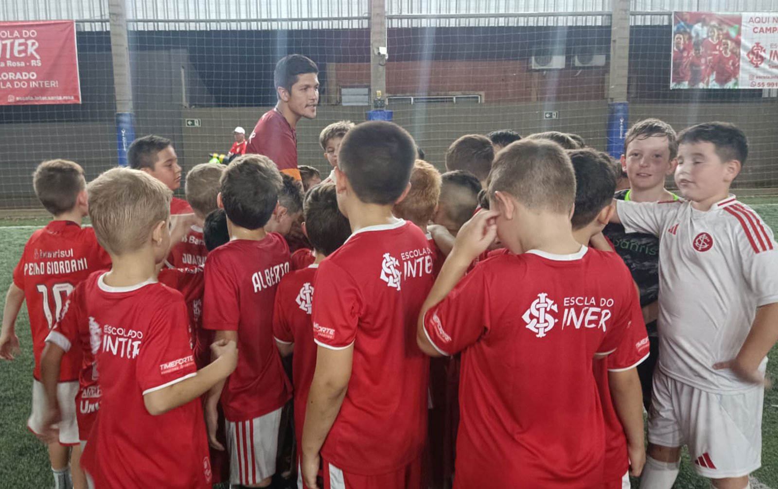 Alunos da Escola do Inter reunidos com o professor antes do treino